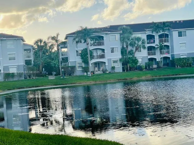 a front view of a house with garden and lake view