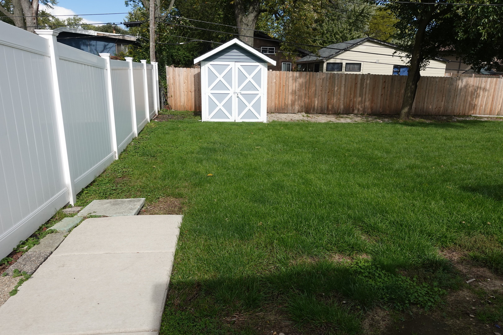 585 Ranger Drive Chicago Heights, IL 60411 - Photo 42 of 48 a backyard of a house with lots of green space and wooden fence