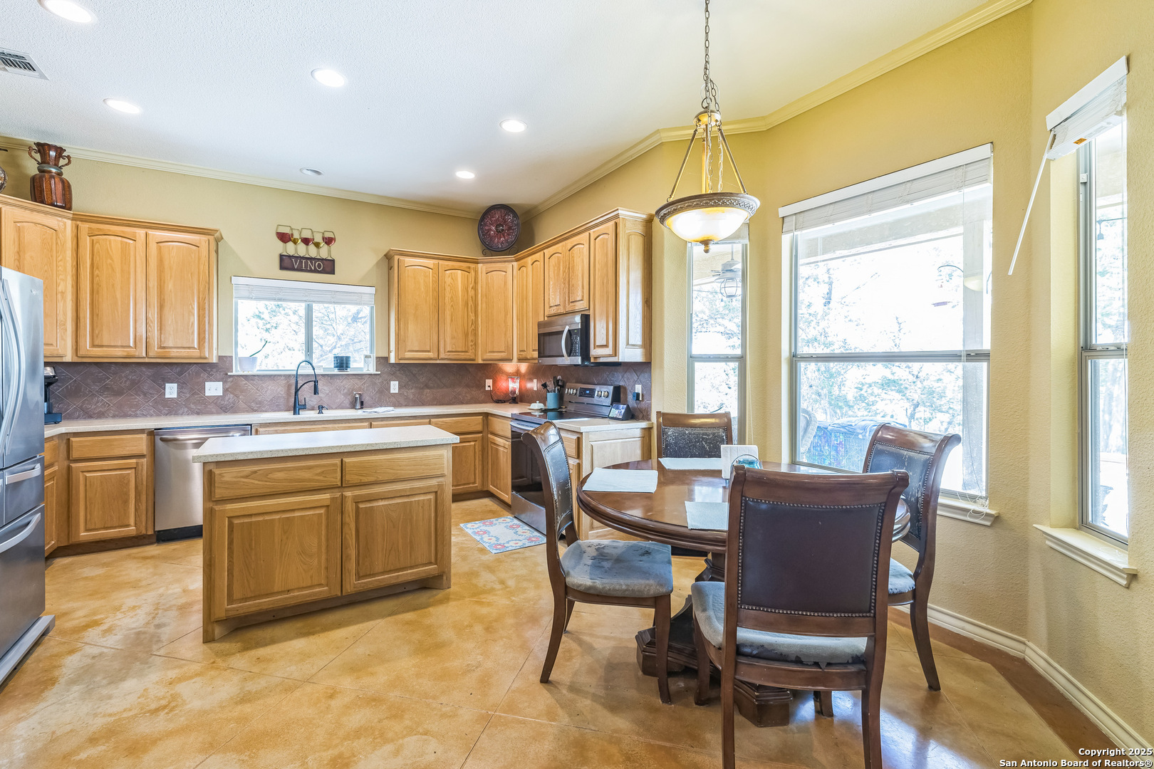 448 Western Bandera, TX 78003 - Photo 14 of 35 a kitchen with granite countertop a stove dining table chairs and granite counter tops