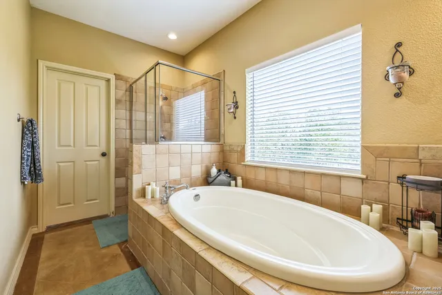 a white bath tub sitting in a bathroom next to a window