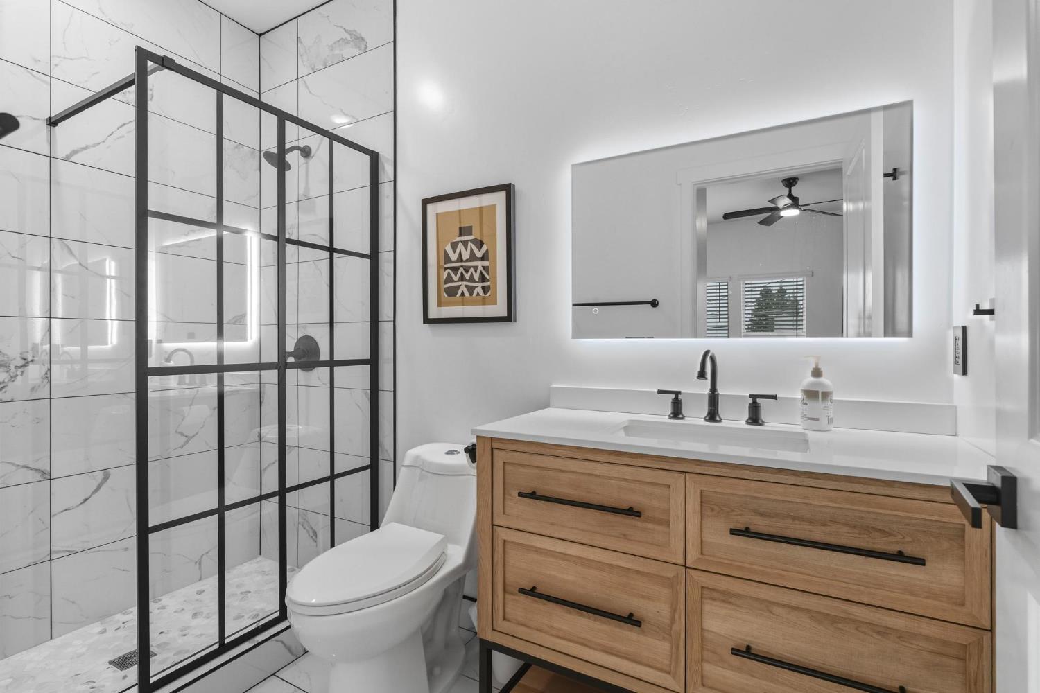 622 North Stockton Avenue Ripon, CA 95366 - Photo 6 of 34 a bathroom with a granite countertop toilet sink and mirror