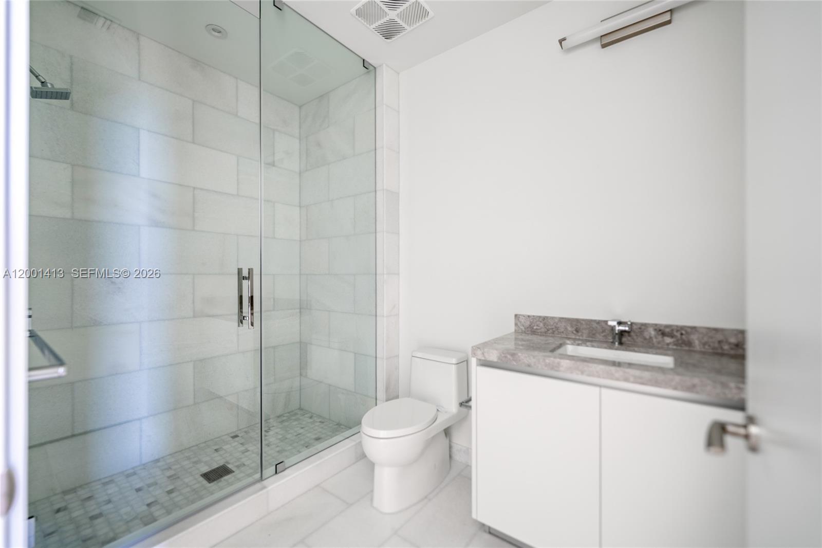 175 Southeast 25th Road, Unit 501 Miami, FL 33129 - Photo 32 of 67 a bathroom with a granite countertop sink a toilet and shower