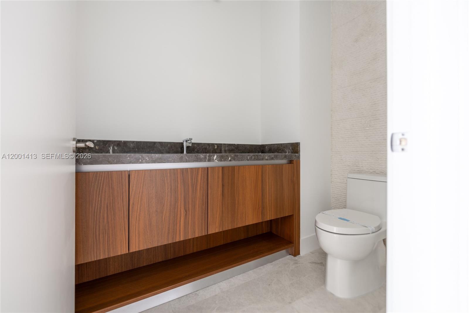 175 Southeast 25th Road, Unit 501 Miami, FL 33129 - Photo 33 of 67 a bathroom with a granite countertop toilet and a sink