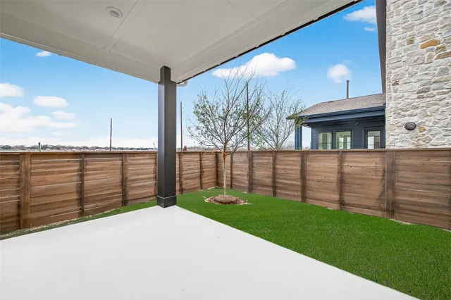 a view of a backyard with wooden fence