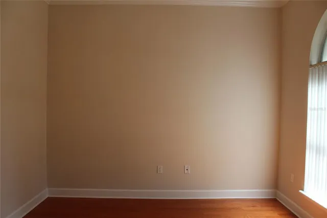 a view of a small space with wooden floor and a window