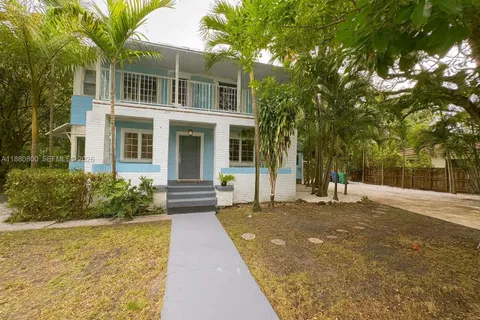 a front view of a house with a yard and potted plants