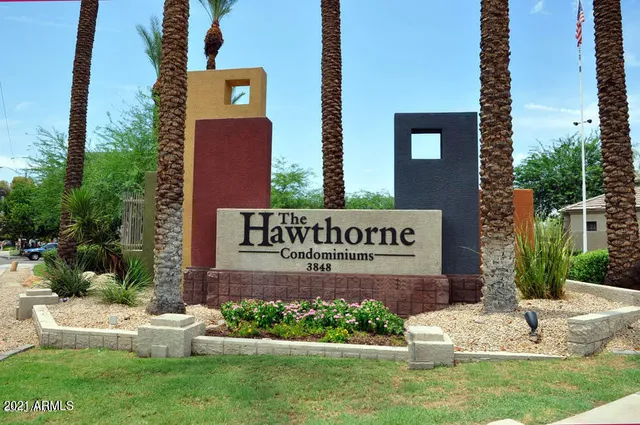 a view of sign board with yard and flowers