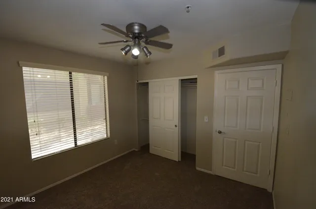 a view of a livingroom with a ceiling fan and window