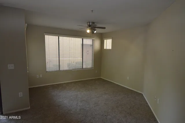 en empty room with windows and ceiling fan