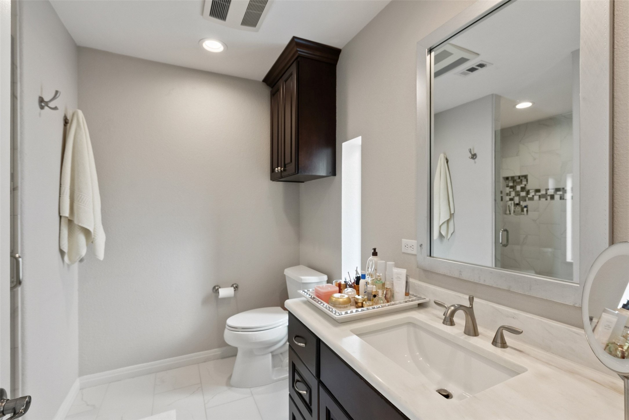 8215 Dark Ridge Cove Austin, TX 78737 - Photo 27 of 40 The private en suite bath is nicely appointed with an updated vanity, floor tile, cabinets, and walk-in shower.