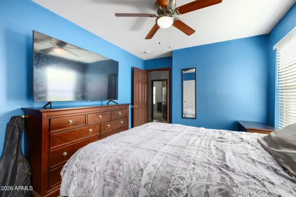 a bedroom with a bed and a mirror on the dresser