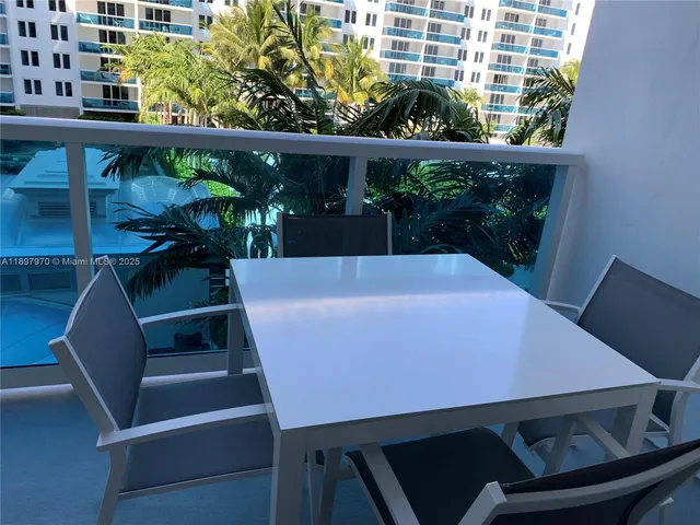 a view of a balcony with table and chairs and potted plants