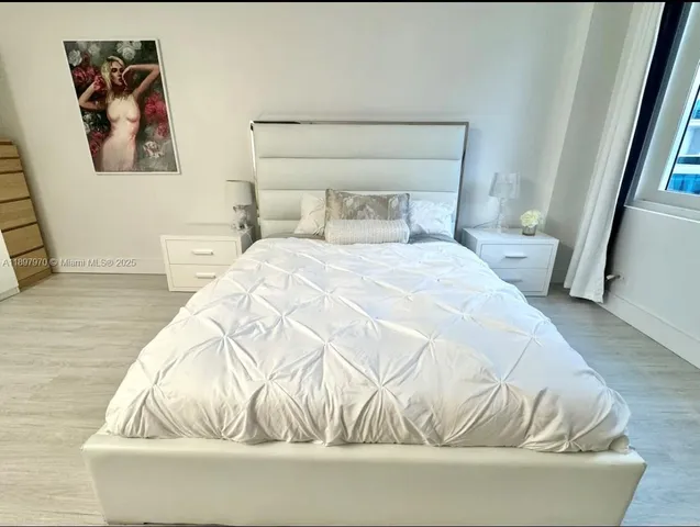 a bedroom with a bed and painting on the wall