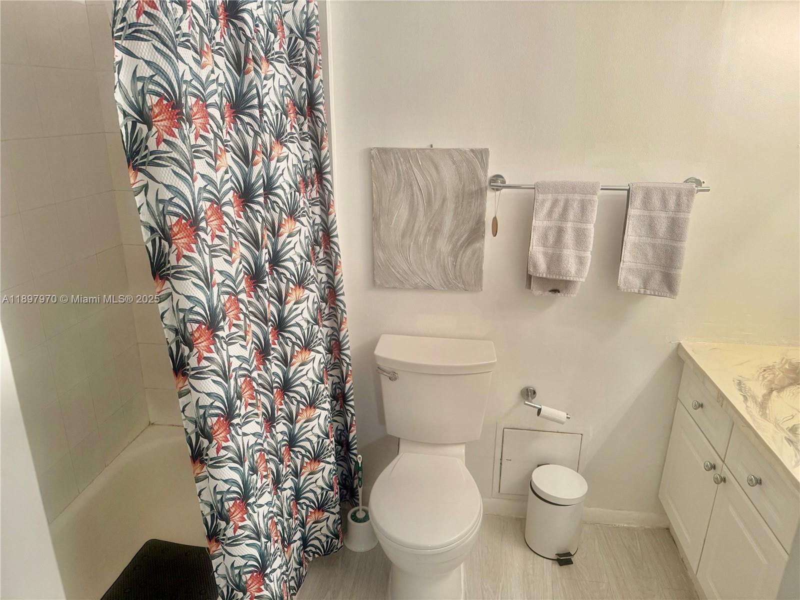 2301 Collins Avenue, Unit 619 Miami Beach, FL 33139 - Photo 9 of 16 a white toilet sitting next to a shower curtain