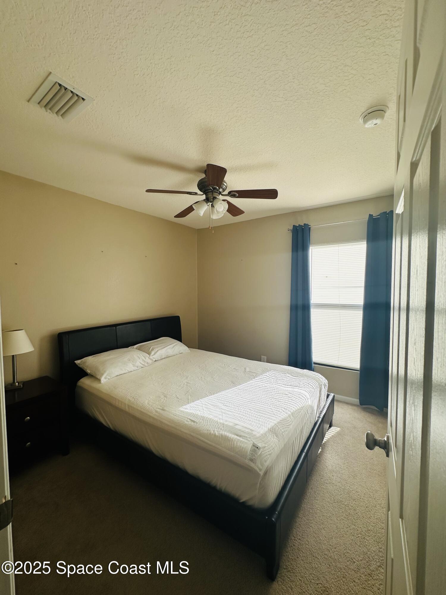 890 Luminary Circle, Unit 103 Melbourne, FL 32901 - Photo 8 of 13 a bedroom with a bed and a table