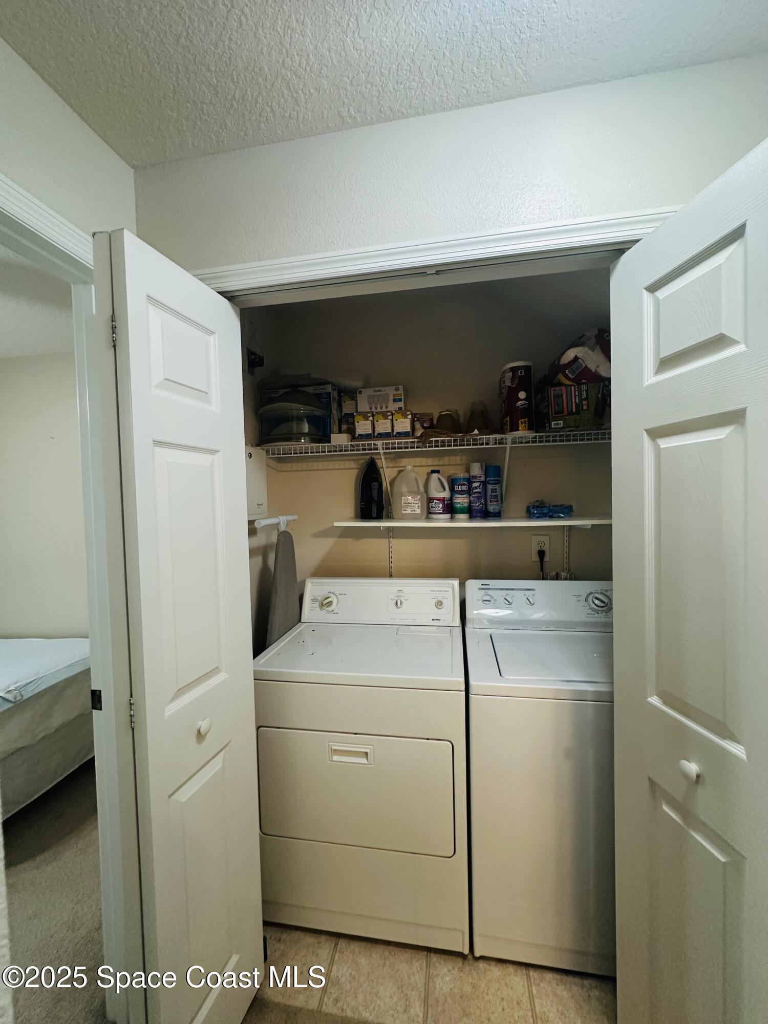 890 Luminary Circle, Unit 103 Melbourne, FL 32901 - Photo 9 of 13 a view of washer and dryer with kitchen in the background
