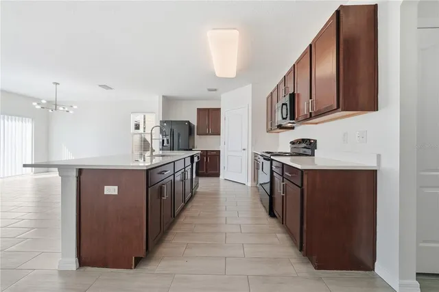 a kitchen with stainless steel appliances granite countertop a stove a sink and a refrigerator