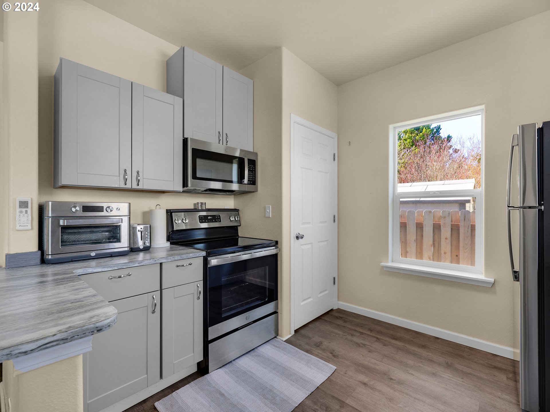 118 Main Street Southwest Ilwaco, WA 98624 - Photo 17 of 44 a kitchen with stainless steel appliances granite countertop a stove a sink and a microwave