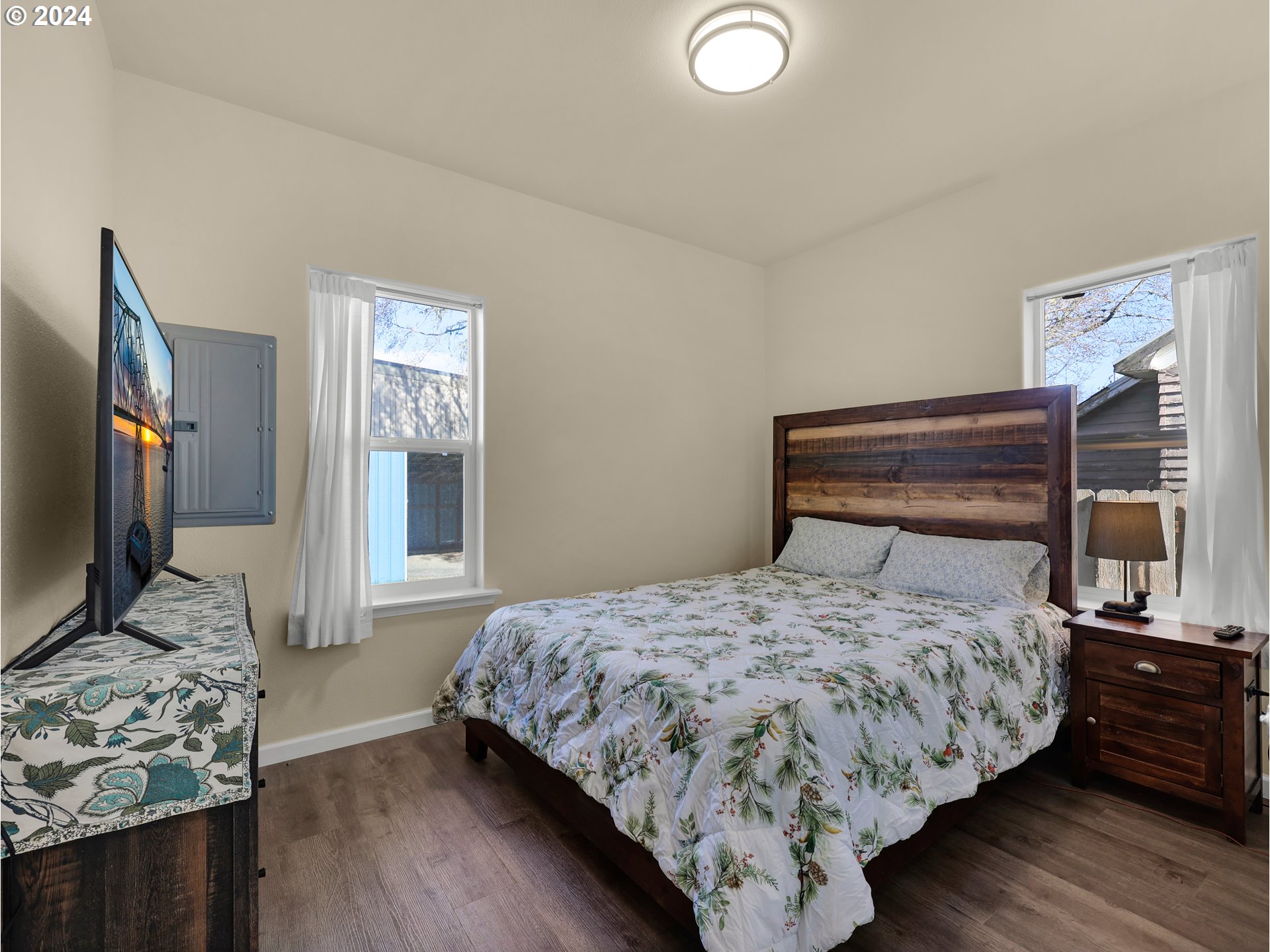 118 Main Street Southwest Ilwaco, WA 98624 - Photo 25 of 44 a bedroom with a bed and a flat tv screen on a dresser