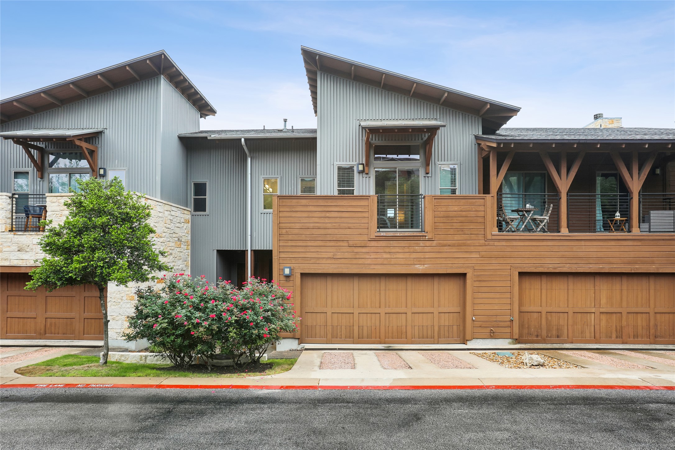 8110 Ranch Road 2222, Unit 10 Austin, TX 78730 - Photo 2 of 23 a front view of a house with a yard and garage