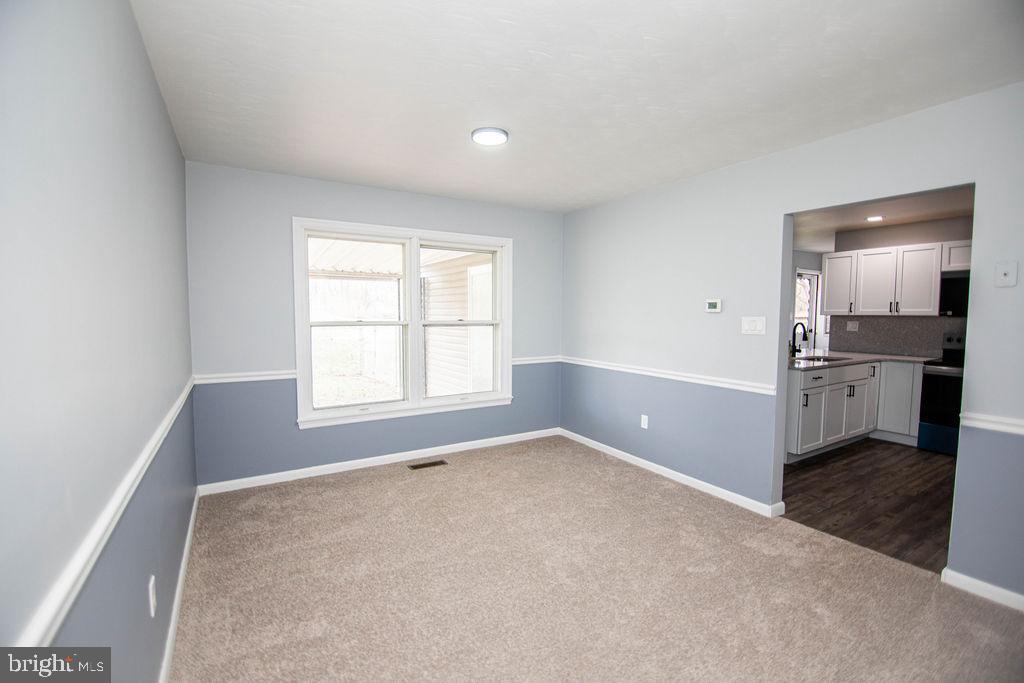 245 Windy Hill Road Shermans Dale, PA 17090 - Photo 16 of 42 an empty room with windows and kitchen view