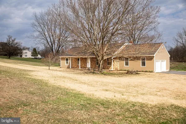 a front view of a house with a yard and trees