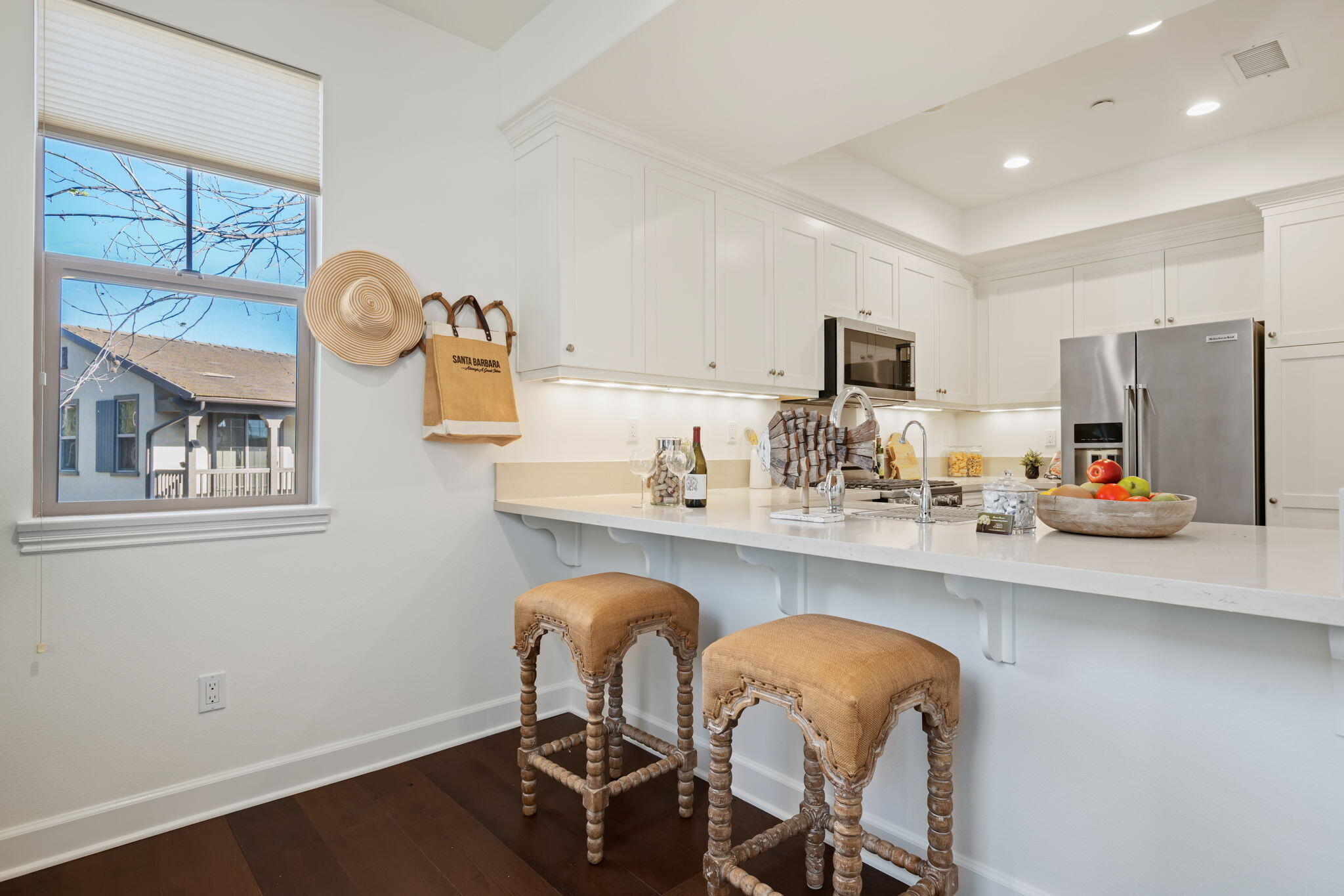 7863 Whimbrel Lane Goleta, CA 93117 - Photo 9 of 22 a kitchen with stainless steel appliances kitchen island granite countertop a dining table chairs and a refrigerator