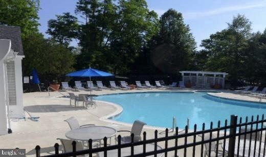 10198 Oakton Terrace Road Oakton, VA 22124 - Photo 22 of 22 a view of a swimming pool with table and chairs under an umbrella