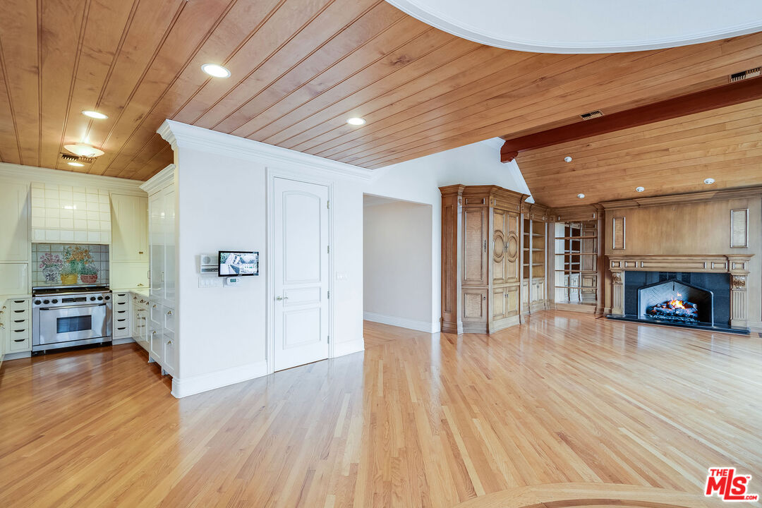 10045 Valley Spring Lane Toluca Lake, CA 91602 - Photo 11 of 36 a view of a livingroom with wooden floor and a fireplace