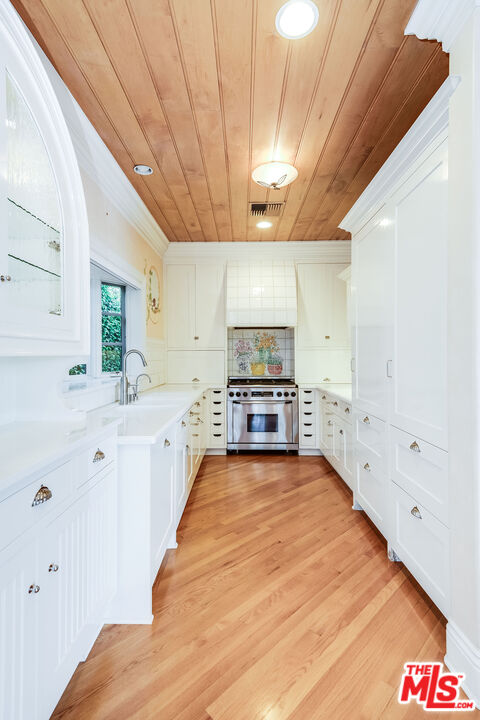 10045 Valley Spring Lane Toluca Lake, CA 91602 - Photo 12 of 36 a large white kitchen with a large window