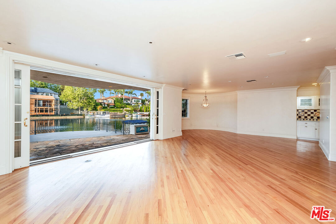 10045 Valley Spring Lane Toluca Lake, CA 91602 - Photo 23 of 36 a view of empty room with wooden floor and fan