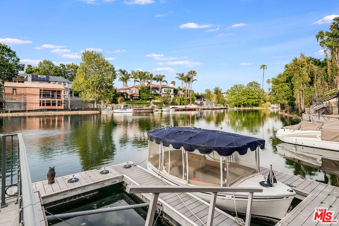 10045 Valley Spring Lane Toluca Lake, CA 91602 - Photo 26 of 36 a view of a lake with a table and chairs under an umbrella