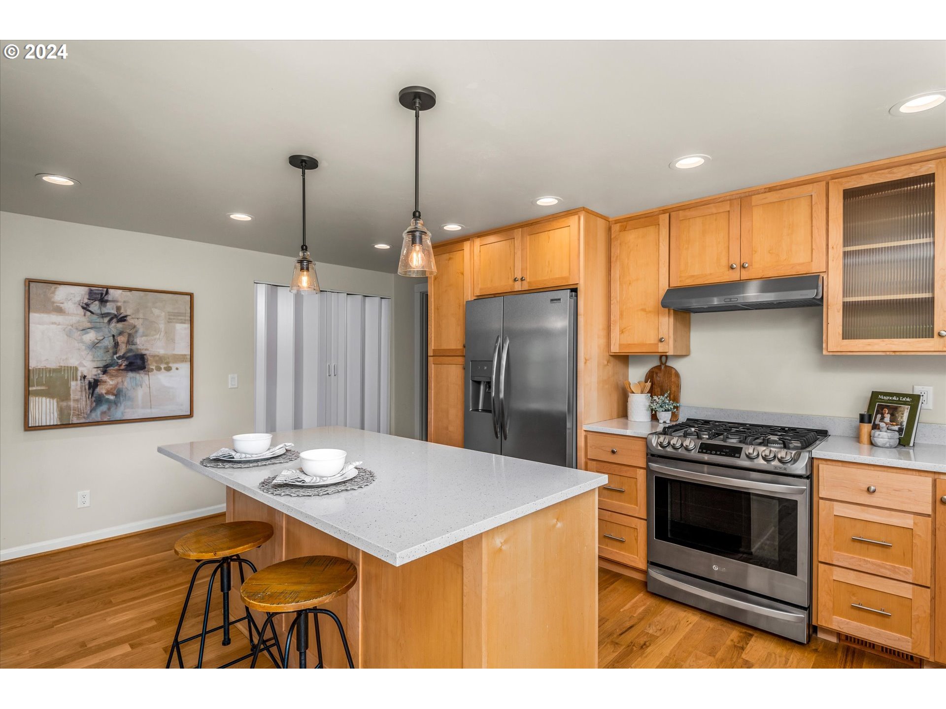 2602 Agate Street Eugene, OR 97403 - Photo 11 of 37 a kitchen with stainless steel appliances kitchen island a table chairs in it and wooden floors