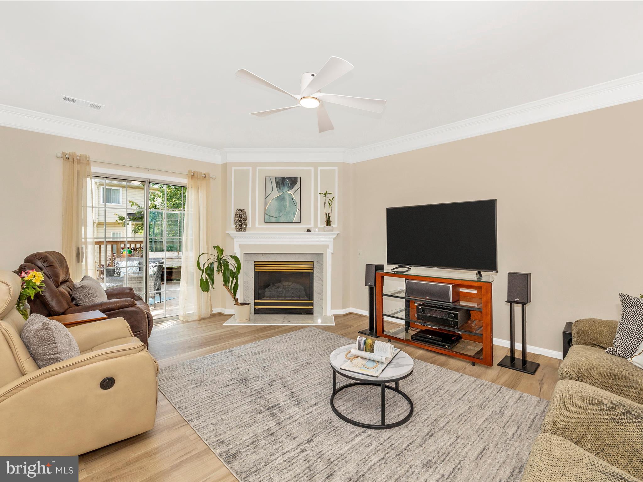 21405 Emerald Drive Germantown, MD 20876 - Photo 9 of 51 a living room with furniture a fireplace and a flat screen tv with wooden floor