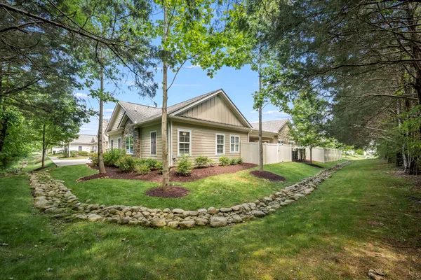 a front view of a house with a yard and trees
