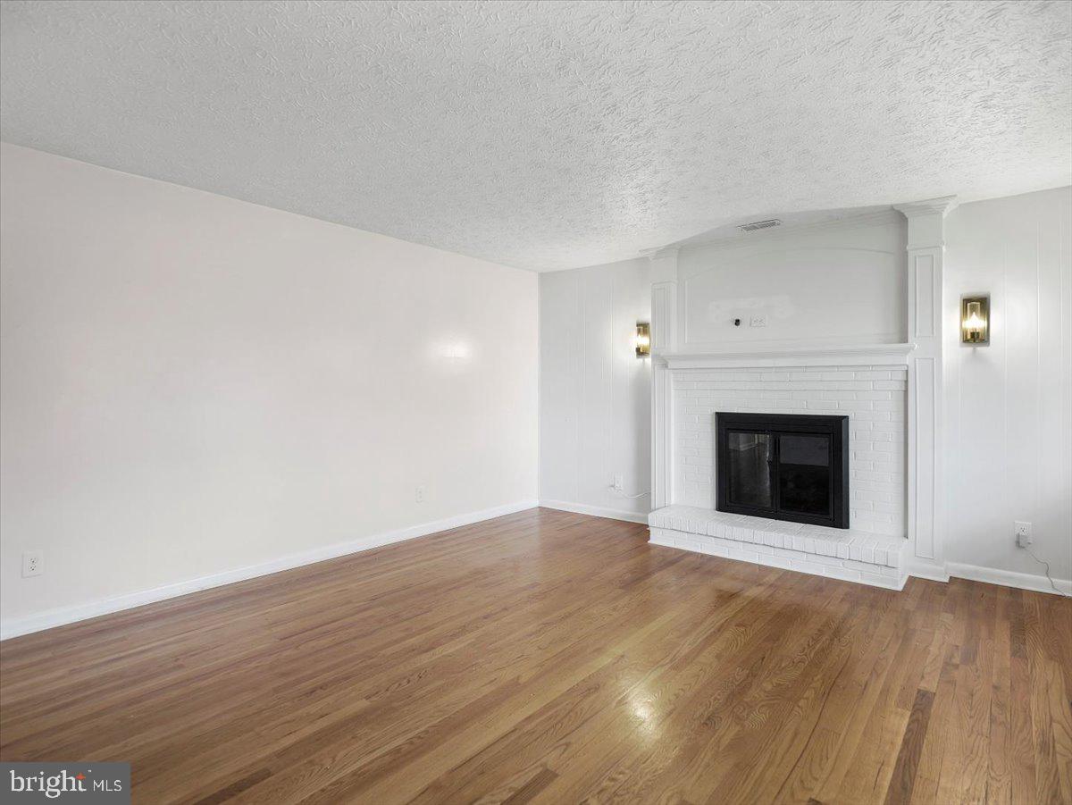 570 Welltown Road Winchester, VA 22603 - Photo 4 of 29 a view of an empty room with wooden floor and a fireplace