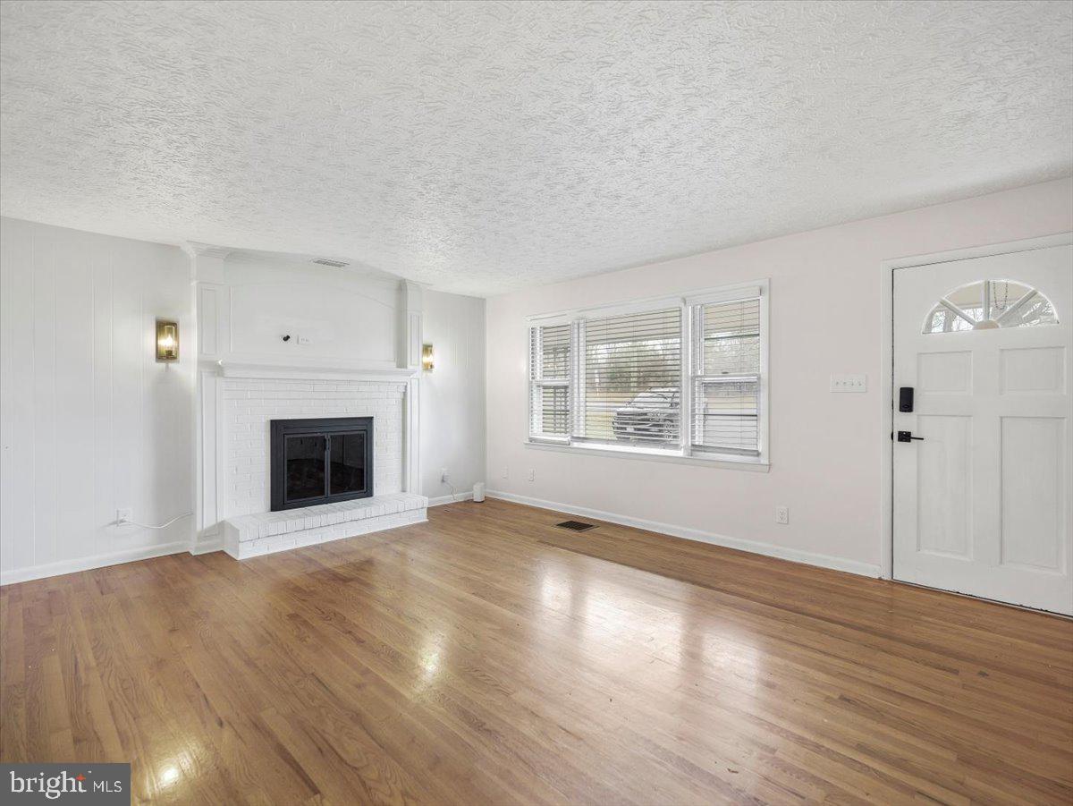 570 Welltown Road Winchester, VA 22603 - Photo 5 of 29 a view of empty room with wooden floor and fireplace
