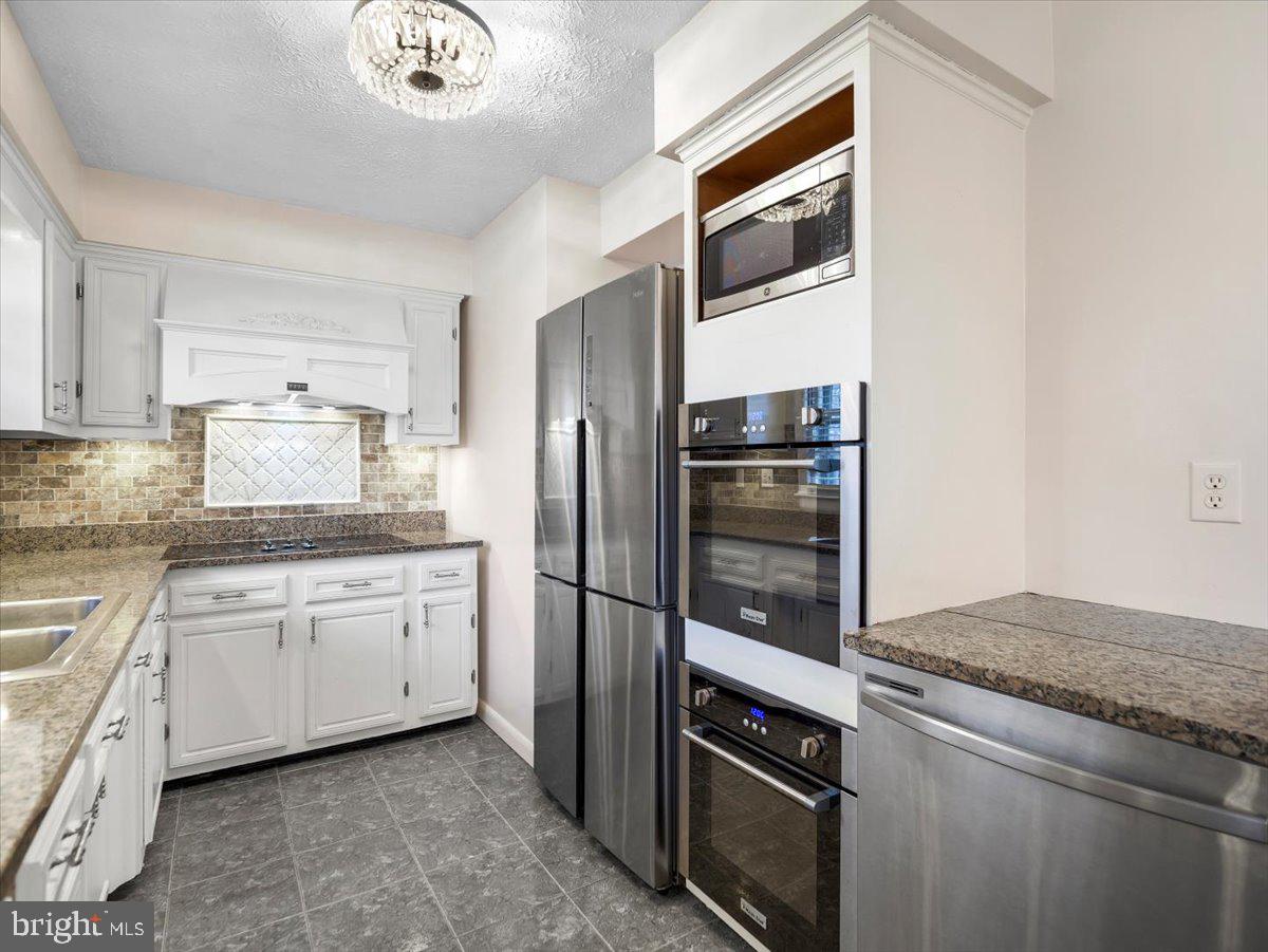 570 Welltown Road Winchester, VA 22603 - Photo 8 of 29 a kitchen with granite countertop stainless steel appliances and wooden cabinets