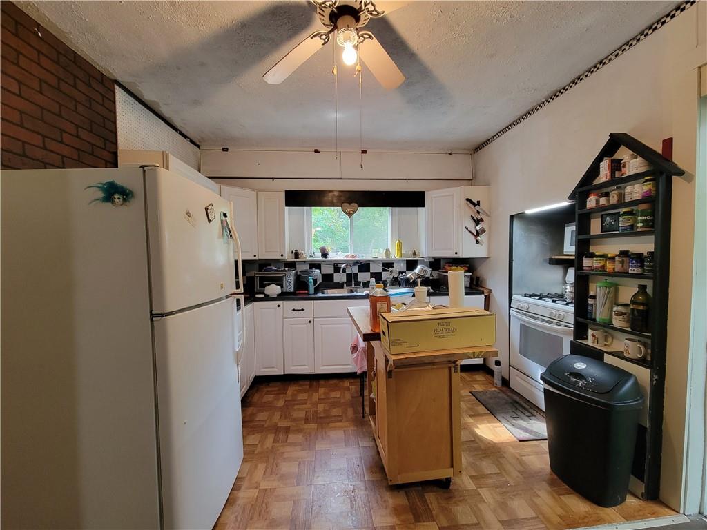 227 Crystal Spring Road Sandy Lake, PA 16145 - Photo 32 of 50 a kitchen with a refrigerator and a stove