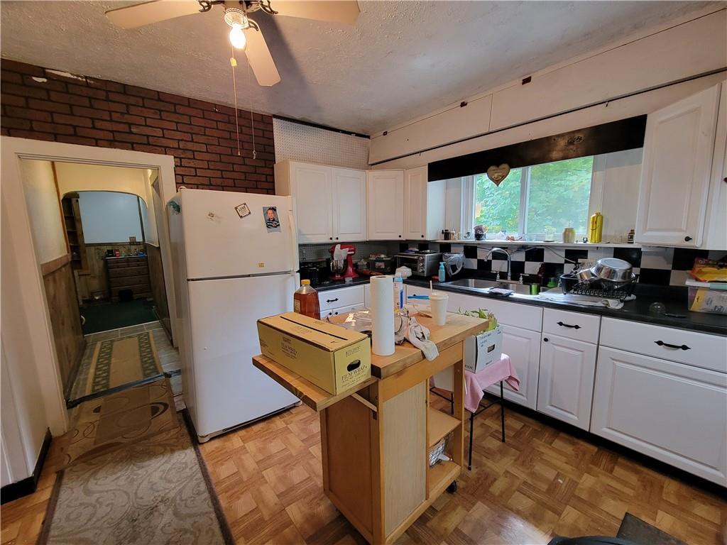 227 Crystal Spring Road Sandy Lake, PA 16145 - Photo 33 of 50 a kitchen with stainless steel appliances granite countertop a refrigerator a sink dishwasher a stove and a dining table with wooden floor