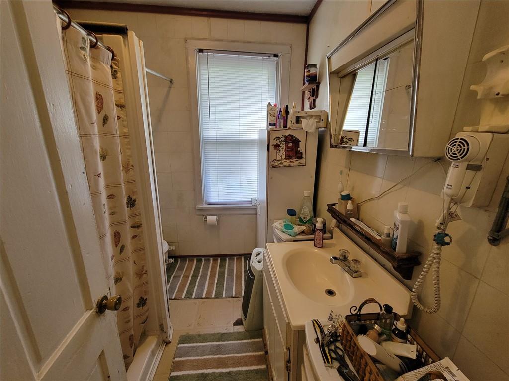 227 Crystal Spring Road Sandy Lake, PA 16145 - Photo 35 of 50 a bathroom with a sink and mirror with bathtub