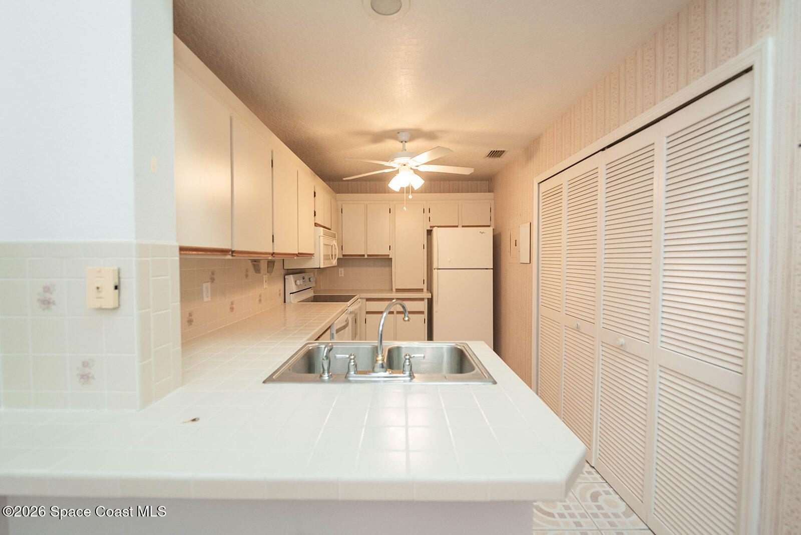 1954 Quail Ridge Court, Unit 1701 Cocoa, FL 32926 - Photo 40 of 41 a kitchen with a sink and a refrigerator
