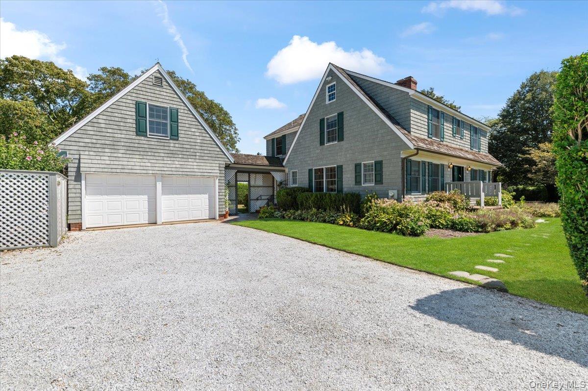 2 Strongs Lane Water Mill, NY 11976 - Photo 2 of 47 View of front of house featuring driveway, a front lawn, a chimney, and an attached garage