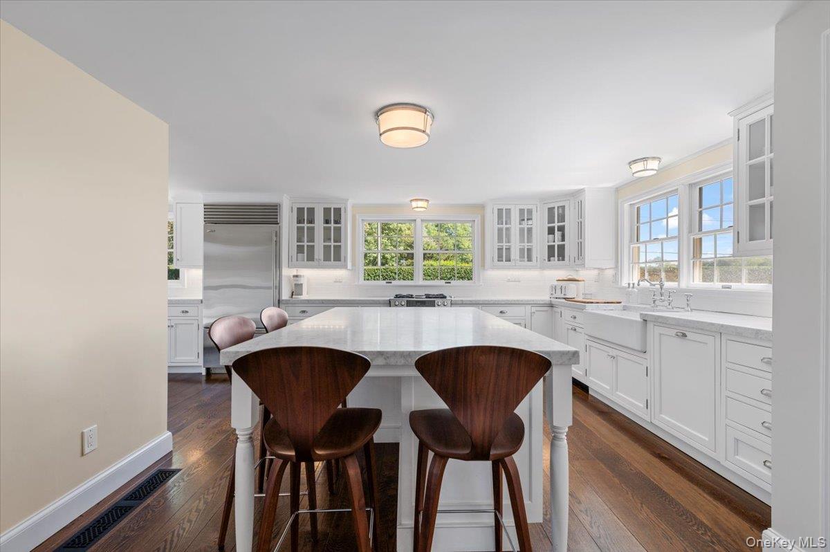 2 Strongs Lane Water Mill, NY 11976 - Photo 21 of 47 Kitchen featuring white cabinets, a kitchen breakfast bar, built in refrigerator, and backsplash