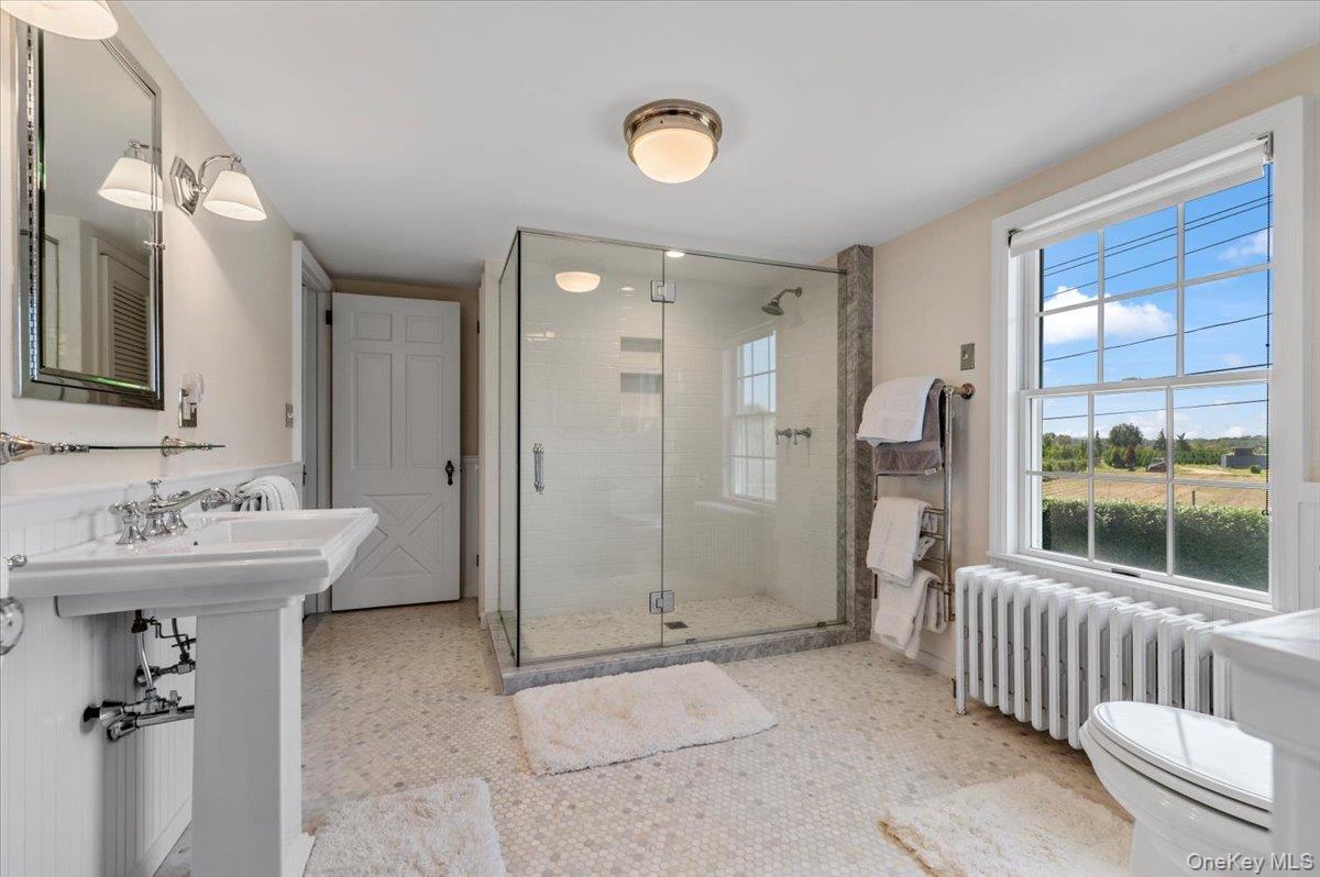2 Strongs Lane Water Mill, NY 11976 - Photo 33 of 47 Full bathroom featuring radiator heating unit, a stall shower, and plenty of natural light