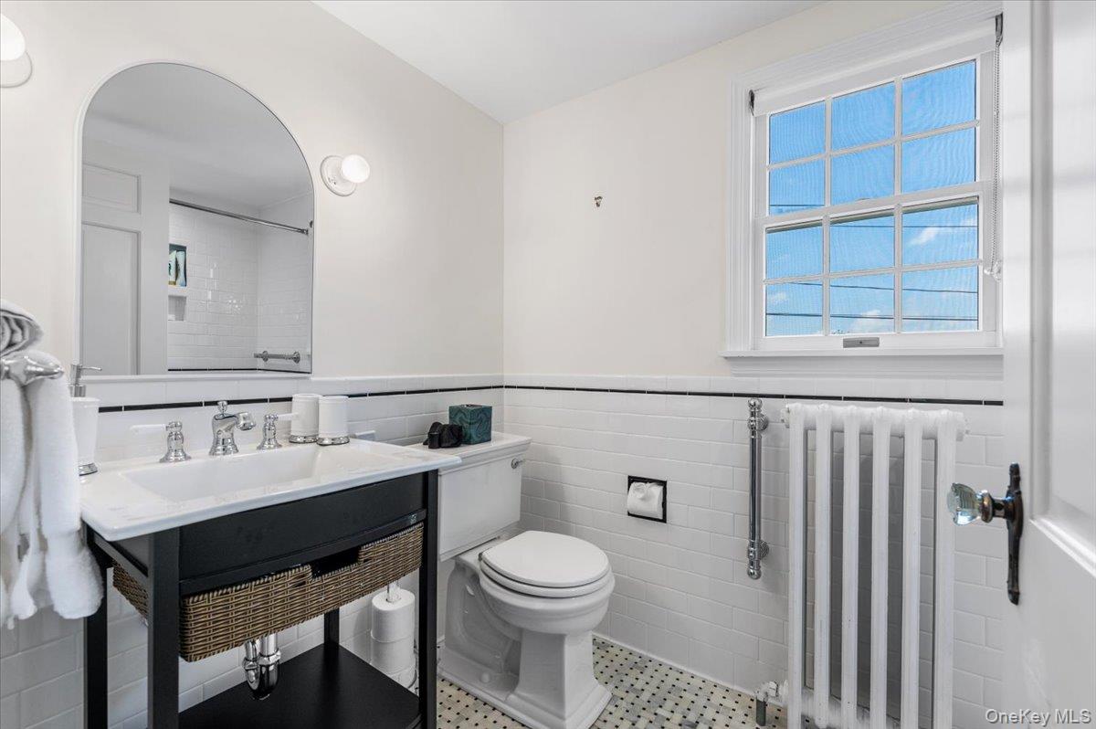 2 Strongs Lane Water Mill, NY 11976 - Photo 34 of 47 Bathroom featuring radiator, tile walls, a wainscoted wall, light tile patterned flooring, and vanity
