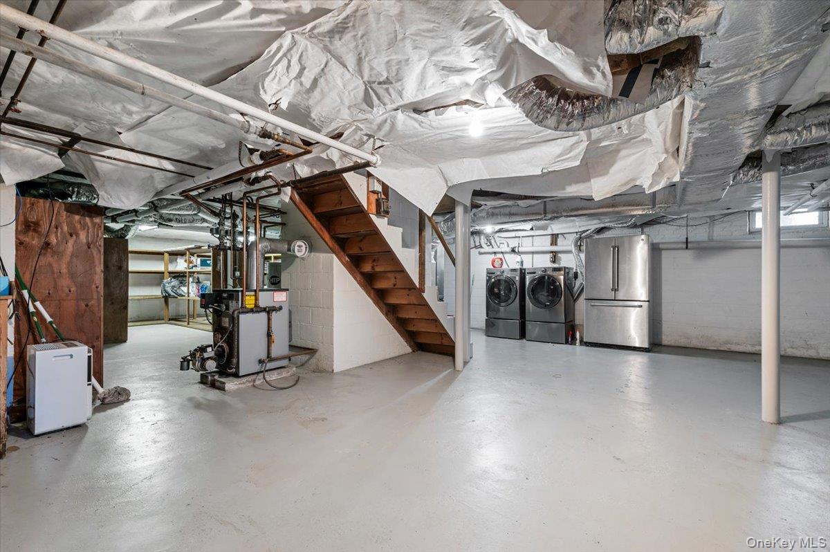 2 Strongs Lane Water Mill, NY 11976 - Photo 42 of 47 Unfinished below grade area with high end refrigerator, a heating unit, separate washer and dryer, and stairway