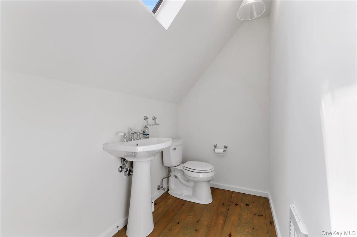 2 Strongs Lane Water Mill, NY 11976 - Photo 46 of 47 Half bath featuring a skylight, lofted ceiling, and dark wood-style flooring