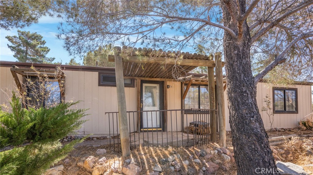 a view of a house with a large tree and wooden fence