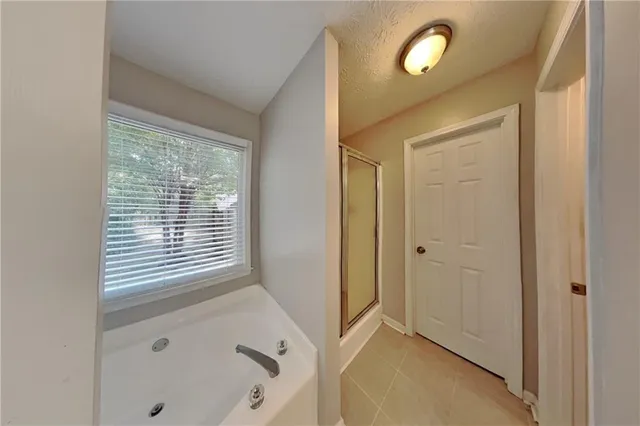 a view of an empty room with a window and a bathroom